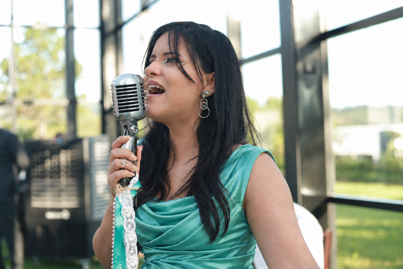 Geisa Mel cantando, com vestido vinho
