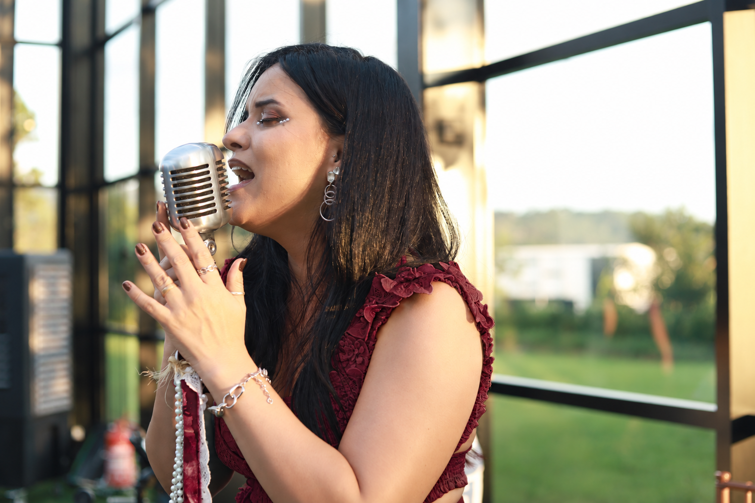 Geisa Mel cantando em vestido vinho